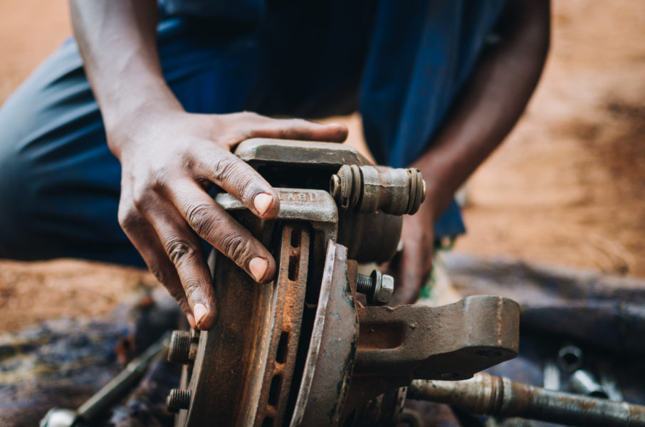 A student working on a brake assembly during motor vehicle mechanics training